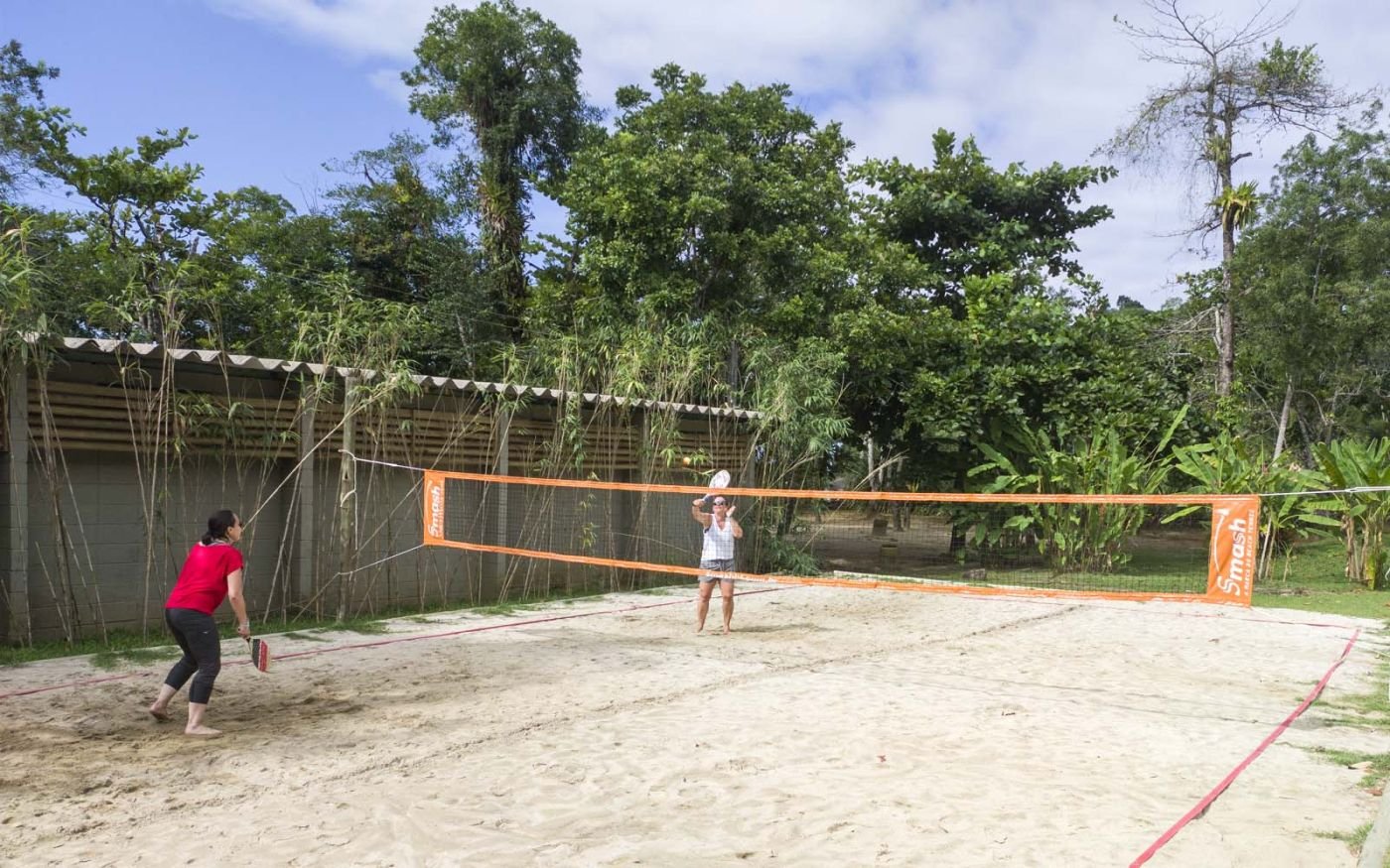 Duas pessoas jogando Beach Tennis na quadra de areia do Itamambuca Eco Resort