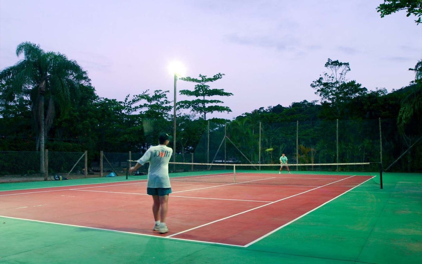 Dois homens praticando Tênis na quadra do Itamambuca Eco Resort